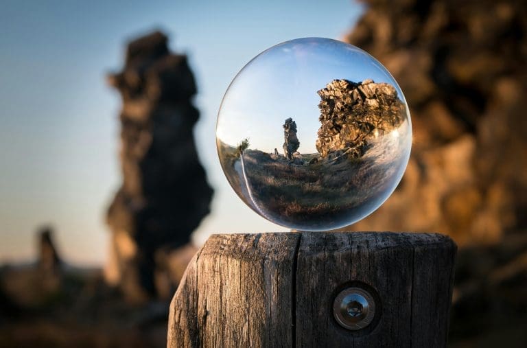 A mesmerizing view through a crystal sphere capturing a rocky landscape at dusk. Perfect for nature and abstract themes.