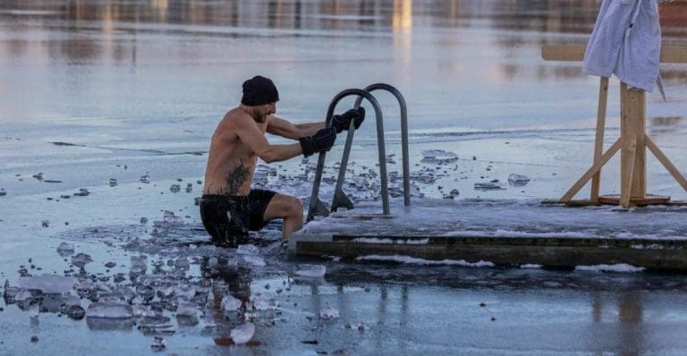 Shirtless man in freezing lake near Ludvika, Sweden, captured during a winter swim. Sublime ice scenery.