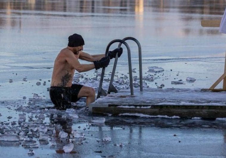 Shirtless man in freezing lake near Ludvika, Sweden, captured during a winter swim. Sublime ice scenery.
