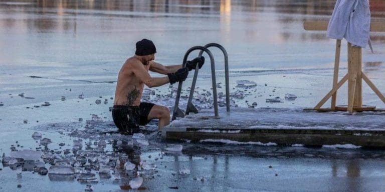 Shirtless man in freezing lake near Ludvika, Sweden, captured during a winter swim. Sublime ice scenery.