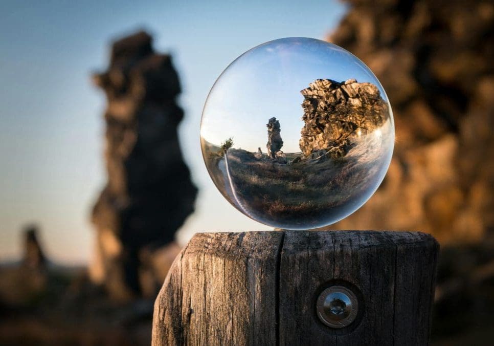 A mesmerizing view through a crystal sphere capturing a rocky landscape at dusk. Perfect for nature and abstract themes.